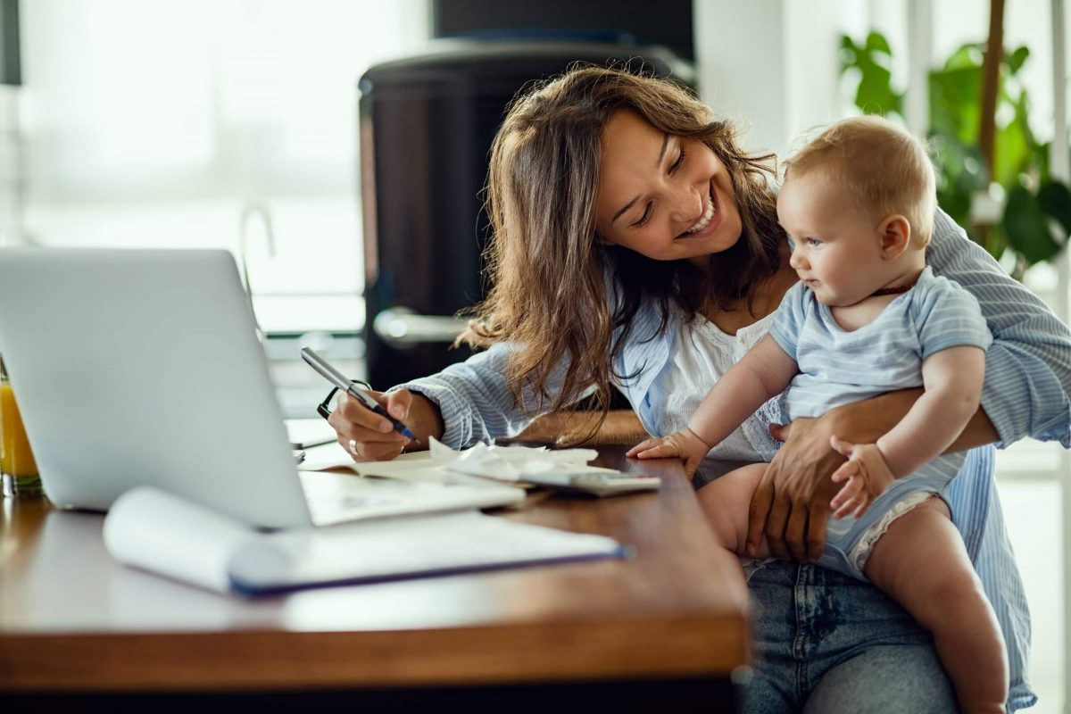 mother-holding-baby-calculating-finances-budget