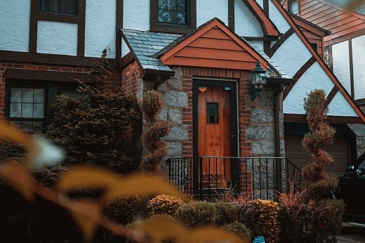 House with fall leaves - Educators home buying in the fall