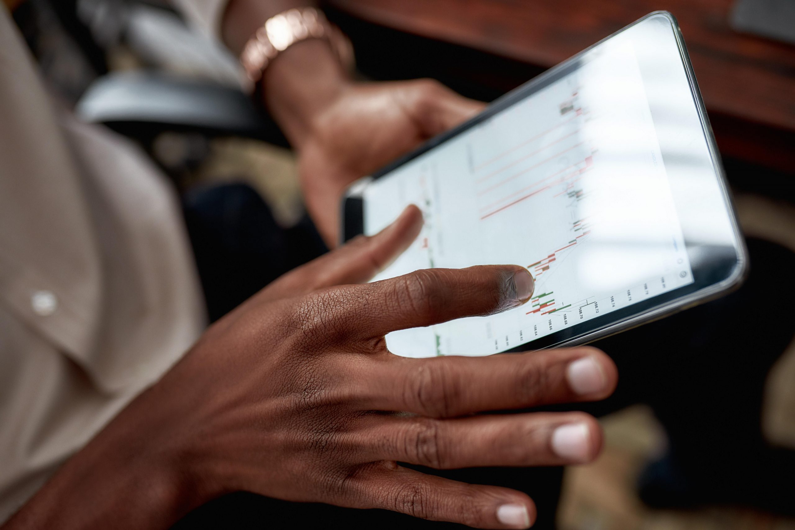 Close up shot of hands holding tablet, analyzing stock market chart, need for rebalancing.