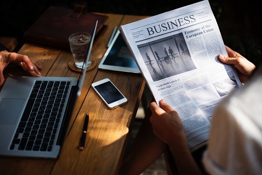 Business newspaper and laptop - Educators Financial Group