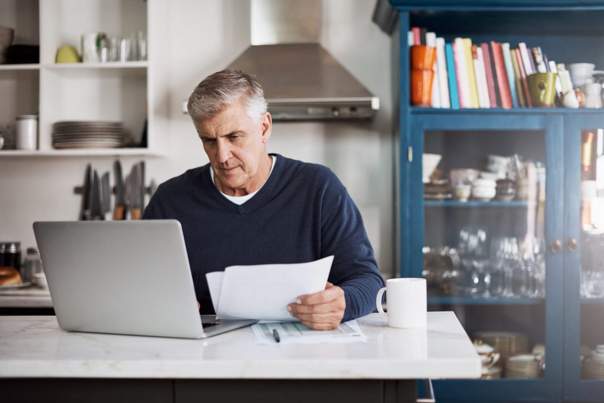man sitting in front of computer reviewing finances