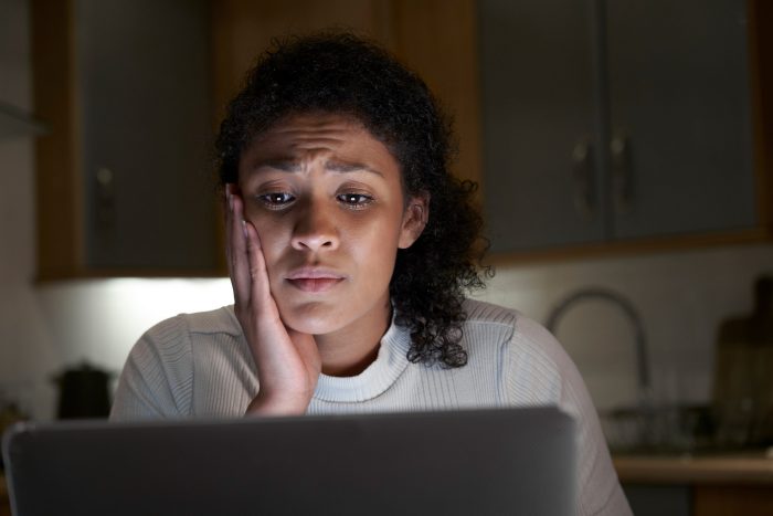 Anxious Woman At Home With Computer